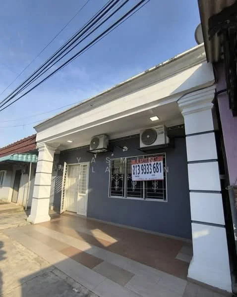 Exterior type: linked terrace house; features: white painted facade, grey accent wall, 2 wall-mounted split AC units, double-door entrance, decorative columns, paved walkway, visible signage, roof overhang, manicured lawn, urban street view; style: modern.