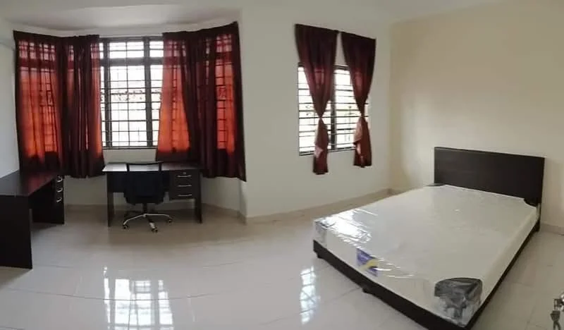 Bedroom features: queen-size bed with mattress, brown wooden bed frame, study desk with drawers, black office chair, white walls, cream painted walls, tile flooring, floor-to-ceiling windows, red curtains, natural light from windows; style: modern.