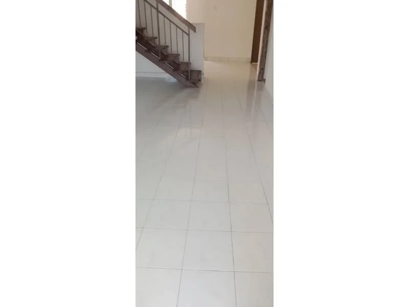 Room features: white tiled flooring, staircase with wooden railing, neutral wall color, natural light from window, open space layout; style: modern.