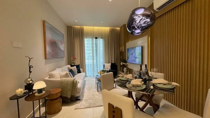 Living features: light grey fabric sofa, cream throw pillows, wooden coffee table, area rug with geometric pattern, wall-mounted TV, decorative wall paneling, recessed lighting, floor-to-ceiling windows with sheer curtains, decorative artwork on wall, hanging pendant light, dining table with four chairs, glass vase with flowers; style: modern.