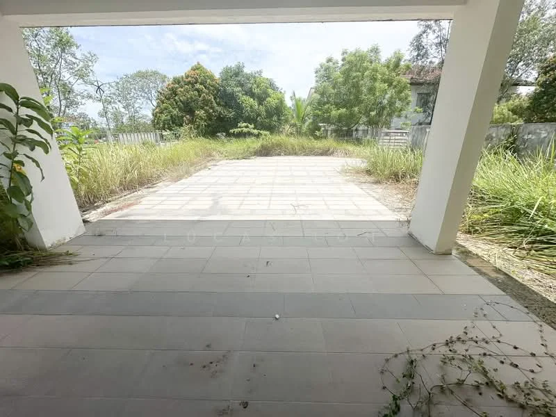 Exterior features: paved outdoor area, overgrown grass, surrounding trees, fenced perimeter, sunlight exposure, clear sky.