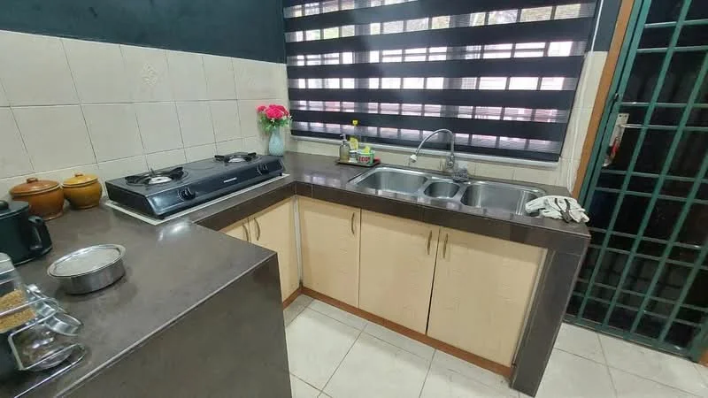 Kitchen features: double-bowl stainless-steel sink, chrome pull-down faucet, granite countertop, cream cabinetry, gas stove with 2 burners, tile backsplash, white tiled walls, ceramic tile flooring, black roller blinds, window with view to outside, kitchen utensils on countertop, decorative vase with flowers; style: modern.
