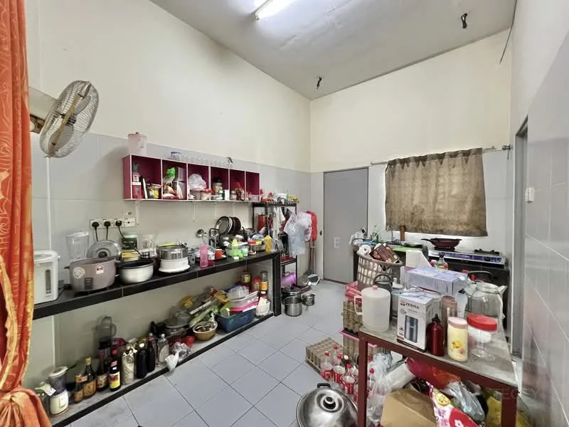 Kitchen features: white tiled walls, grey tiled flooring, black countertop, open shelving with red backing, various kitchen appliances visible, multiple cooking pots and pans, bottles and jars on shelves, window with brown curtain, ceiling fan, sink, kitchen utensils, stainless-steel pot, plastic containers, rice cooker, stove.