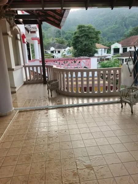 Room features: tiled flooring, covered balcony, white railing, decorative columns, mountain view, outdoor seating, red accents on walls, surrounding greenery; style: traditional; view: mountain.