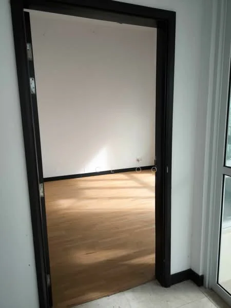Room features: wooden flooring, white painted walls, black door frame, natural light from window, no visible furniture.