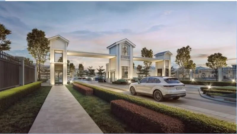Exterior type: main entrance gate; features: gated entrance, two-storey entrance structure, landscaped garden with hedges, paved walkway, driveway with interlocking pavers, security guard house, outdoor lighting, mature trees, surrounding fence, modern architectural design; style: modern.