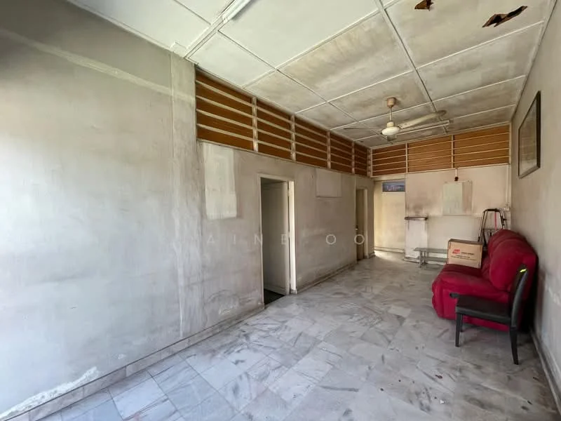 Room features: white painted walls, exposed ceiling with visible beams, marble tile flooring, ceiling fan, window with wooden slats, red fabric sofa, black chair, doorway leading to another room, wall-mounted frame, corner with plumbing fixtures; style: minimalist.