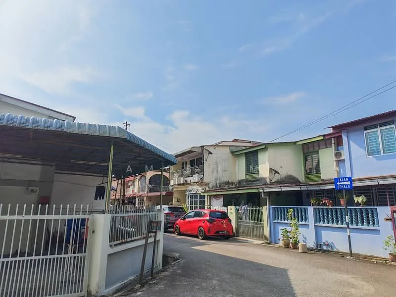 Exterior type: linked terrace house; features: two-storey linked terrace houses, painted facade in pastel colors, balconies on upper floors, metal roof with overhang, fenced front yard, paved driveway, street sign visible, surrounding residential area, clear blue sky; style: modern.