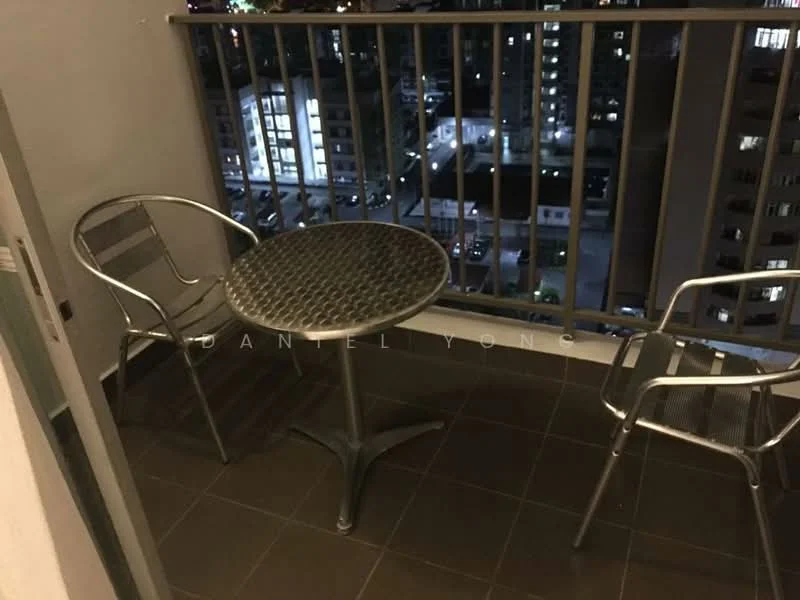 Balcony features: metal table with round top, two metal chairs, grey tiled flooring, railing with vertical bars, city skyline view at night; style: modern; view: city.