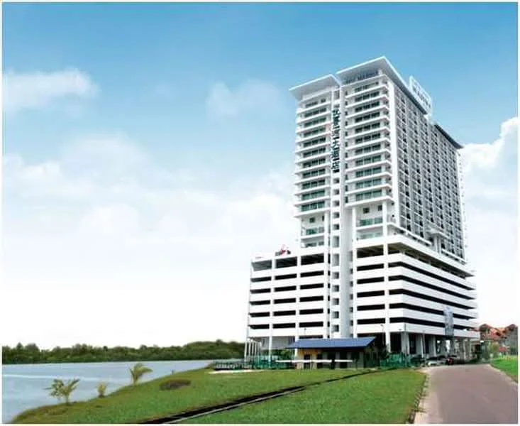 Exterior type: high-rise condominium; features: white painted facade, glass curtain wall, flat roof, approximately 15-storey high-rise, manicured lawn, surrounded by water, balconies on upper floors, parking deck, outdoor seating area at ground level; style: modern.