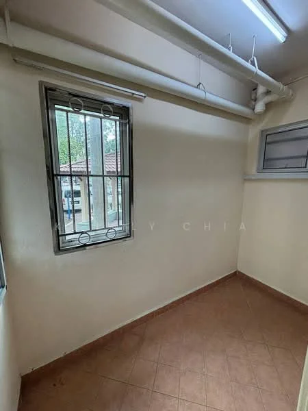 Room features: cream painted walls, brown tiled flooring, window with security bars, ceiling-mounted pipes, fluorescent ceiling lights.