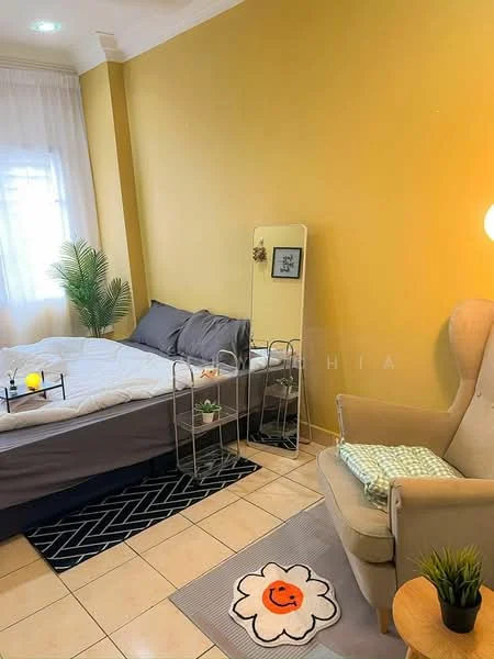 Bedroom features: queen-size bed with grey bedding, yellow painted walls, tile flooring, floor lamp, decorative mirror, green plant in corner, small side table with plants, armchair with light fabric, area rug with flower pattern, window with sheer curtains; style: modern.