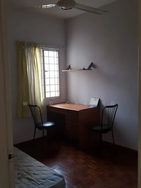 Bedroom features: wooden flooring, light purple painted walls, single window with grid design, sheer yellow curtains, built-in shelf above desk, wooden desk, two black metal chairs, bed with mattress.