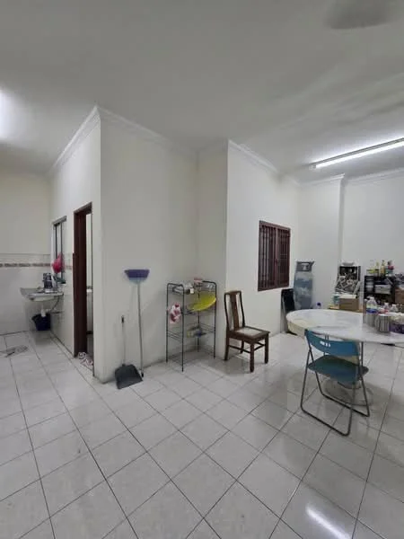 Room features: white painted walls, tile flooring, ceiling lights, window with bars, round dining table, blue chair, wooden chair, cleaning supplies, shelving unit, sink, countertop, various containers, open space layout; style: minimalist.