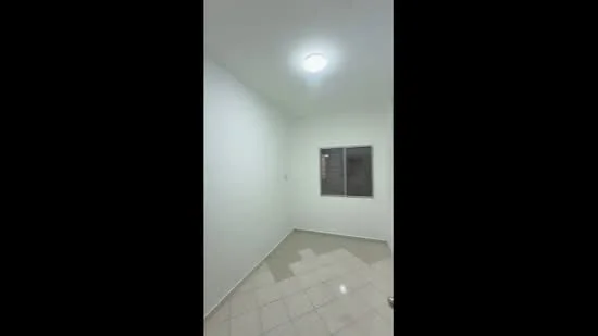 Room features: white painted walls, tile flooring, single ceiling light, window with grid, neutral color scheme.