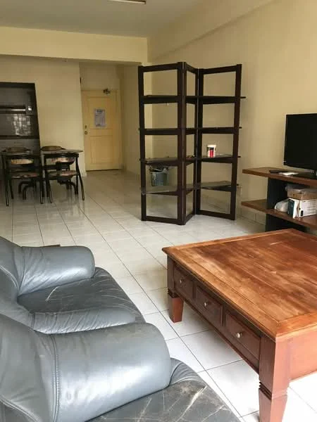 Living features: grey leather sofa, wood coffee table, glass display cabinet, TV console, wall-mounted TV, white tiled flooring, cream painted walls, dining table with chairs, door leading to hallway, open layout; style: modern.
