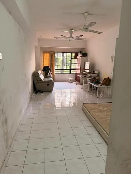 Living features: white painted walls, tiled flooring, 5-blade ceiling fan, large window with sheer curtains, sofa in light color, wooden coffee table, TV console, computer desk, empty mattress on the floor.