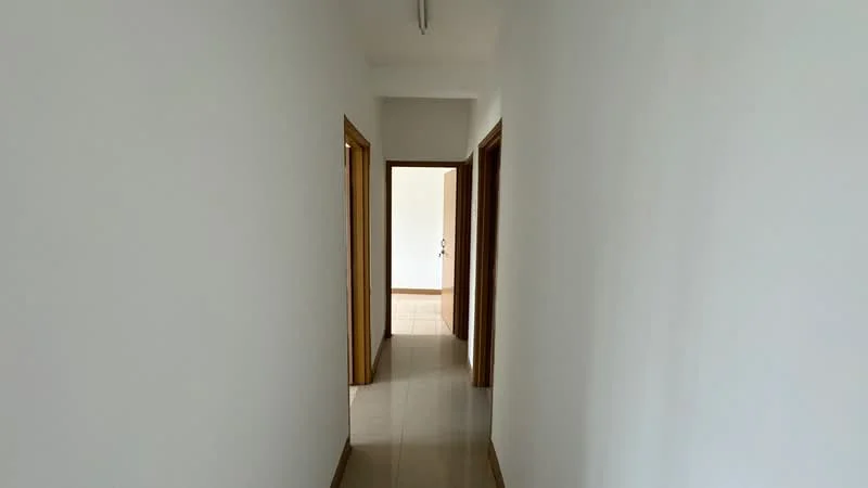 Hallway features: white painted walls, tile flooring, wooden door frames, ceiling lights, neutral color scheme; style: modern.