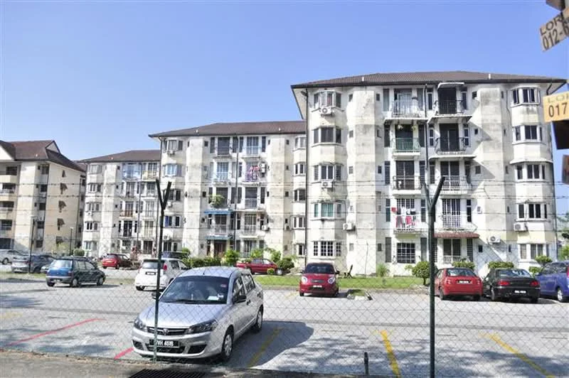 Exterior type: low-rise apartment block; features: concrete facade, balconies with railings, multiple storeys, parking lot in front, landscaped garden area, surrounding greenery, visible air conditioning units, cars parked in designated spaces; style: modern.
