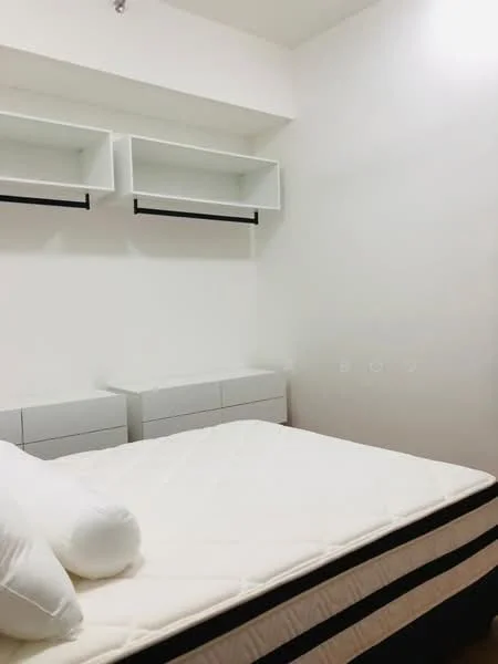 Bedroom features: queen-size bed, white bedding, white throw pillows, built-in wall shelves, light wood bedside cabinets, white painted walls, dark wood flooring, minimalist decor; style: modern.