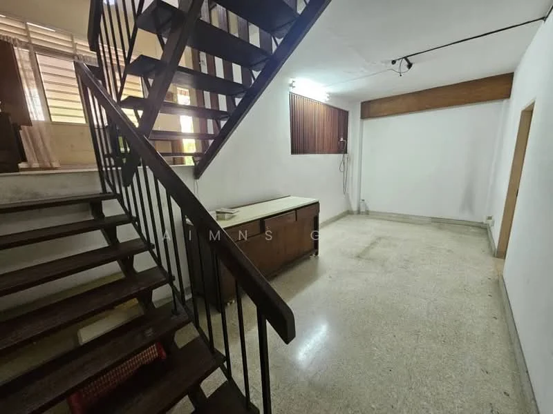 Room features: staircase with wooden steps and metal railing, polished terrazzo flooring, white painted walls, wood paneling on one wall, ceiling light fixture, corner space with no visible furniture, window with natural light, empty space for potential furniture placement; style: minimalist.