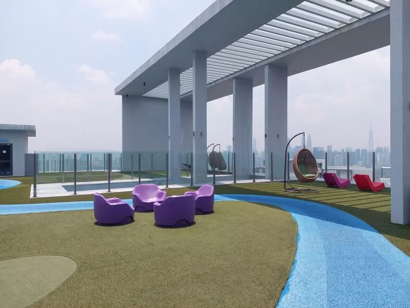 Exterior type: rooftop terrace; features: artificial grass flooring, glass railing, outdoor lounge seating, hanging egg chair, purple lounge chairs, red lounge chairs, open sky, city skyline view; style: modern.