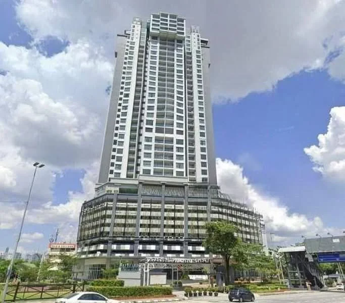 Exterior type: high-rise condominium; features: glass curtain wall, white painted facade, recessed balconies, multiple storeys, surrounded by greenery, urban context, visible parking area, main entrance with awning; style: modern.