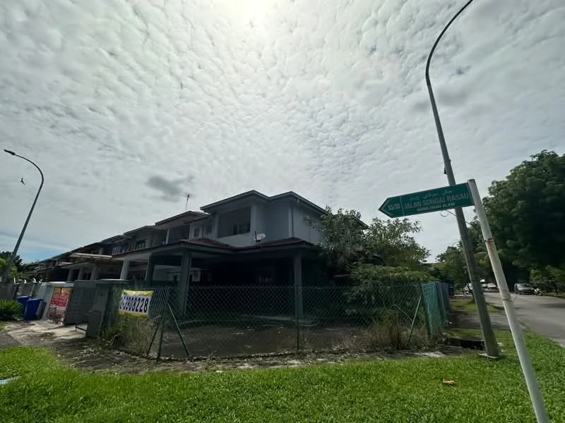 Exterior type: linked terrace house; features: two-storey building, grey painted facade, fenced perimeter, manicured lawn, corner lot, street sign visible, surrounded by greenery, asphalt road, visible utility poles; style: modern.
