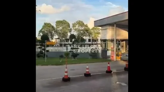 Exterior type: main entrance gate; features: guard house at entrance, manicured lawn, mature trees, paved driveway, traffic cones, security booth, surrounded by greenery; style: modern.