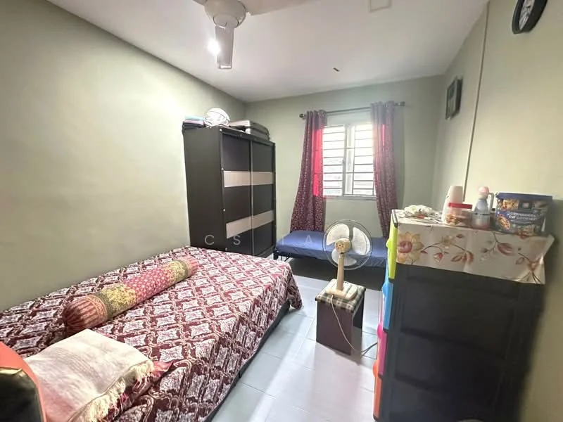 Bedroom features: single bed with patterned bedding, double bed with patterned bedding, black wardrobe with sliding doors, window with metal grille, curtains in red with floral pattern, ceiling fan, small bedside table, decorative wall clock, light grey painted walls, laminate flooring.