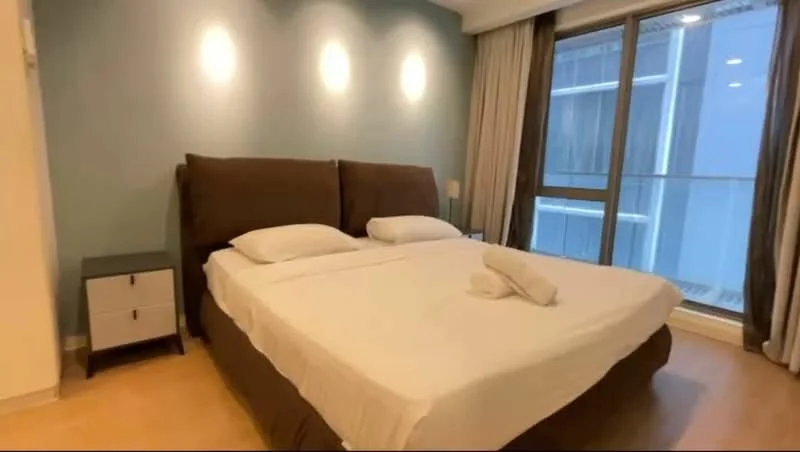 Bedroom features: king-size bed, upholstered headboard, white bedding, 2 bedside tables, table lamps, floor-to-ceiling windows, curtains, wooden flooring, accent wall in light blue, recessed lighting; style: modern.
