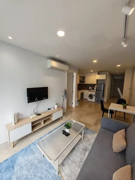 Living features: grey fabric sofa, coffee table with metal frame, area rug with geometric pattern, wall-mounted TV, TV console with storage, 1 wall-mounted split AC, recessed LED downlights, floor-to-ceiling windows, open-plan layout with kitchen, dining table for two, decorative plant, light-colored walls, cream-colored flooring; style: modern. Kitchen features: stainless-steel fridge, built-in oven, freestanding washing machine, kitchen cabinetry, countertop with bar seating, ceramic tile backsplash, 4-burner gas hob, sink, microwave, under-cabinet lighting; style: modern.