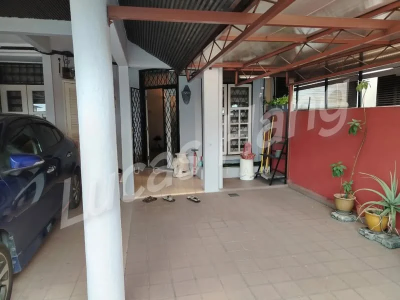 Exterior type: linked terrace house; features: car porch with awning, paved flooring, red accent wall, mature plants in pots, metal roof, open space, entrance to the house visible; style: modern.