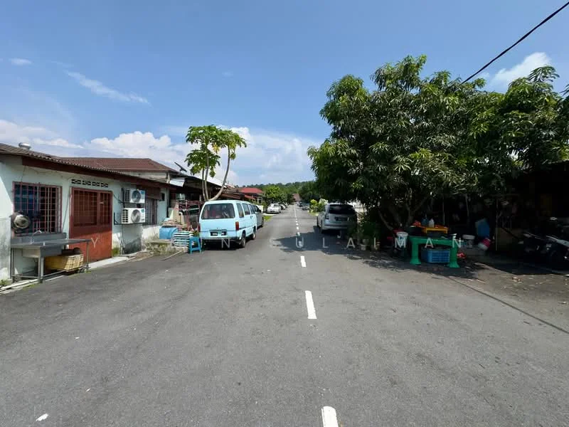 Exterior type: linked terrace house; features: two-storey linked terrace houses, paved road, mature trees lining the street, air conditioning units visible on houses, outdoor baskets or containers, vehicles parked along the street, clear blue sky, sunny weather; style: traditional.