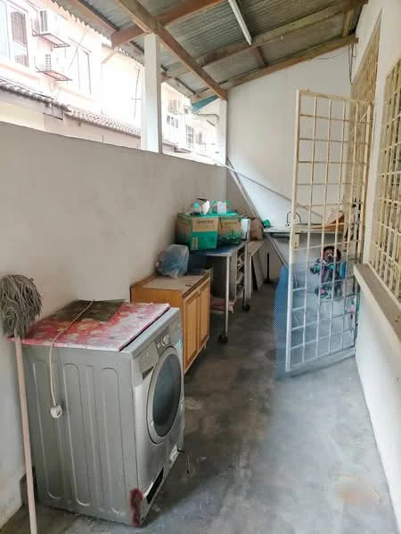 Laundry features: front-load washing machine, wooden cabinet, metal shelving unit, concrete flooring, exposed beams, metal roof, mop, storage boxes, wire mesh door.