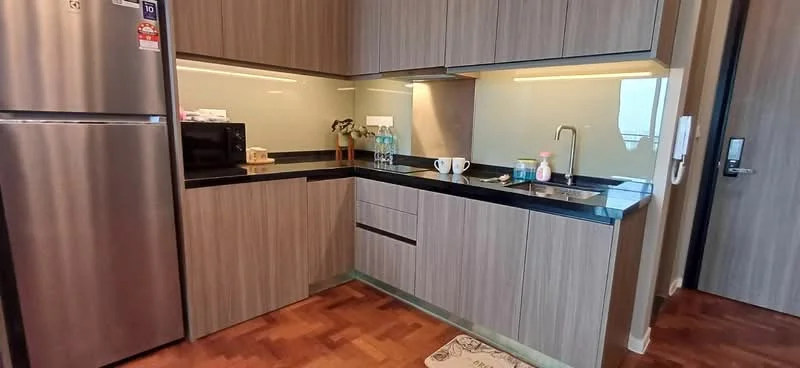 Kitchen features: stainless-steel fridge, built-in microwave, black granite countertop, wood cabinetry with horizontal grain, single-bowl stainless-steel sink, chrome pull-down faucet, glass backsplash, undercabinet lighting, wooden flooring, kitchen rug; style: modern.