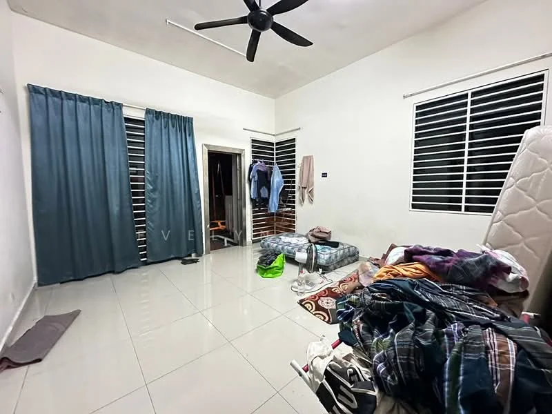 Room features: white painted walls, glossy tile flooring, ceiling fan, two windows with horizontal blinds, unmade mattress on the floor, clothes hanging on the door, clothes on the floor, area rug with geometric pattern.