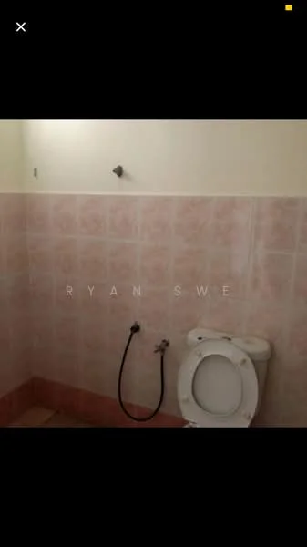 Bathroom features: pink tiled walls, white toilet, bidet spray, shower head, pink tiled flooring.