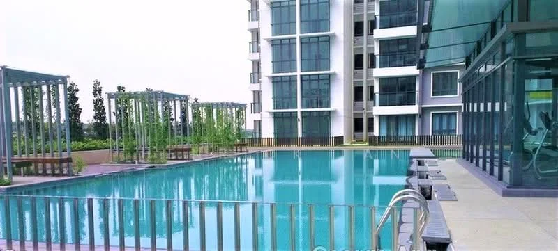 Exterior type: high-rise condominium; features: infinity pool, pool deck with loungers, glass curtain wall facade, manicured landscaping, surrounding greenery, outdoor seating area, modern architecture, multiple storeys, balconies on upper floors; style: modern.