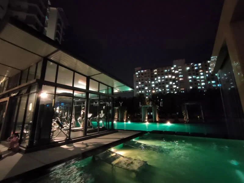 Exterior type: clubhouse; features: glass facade, outdoor swimming pool, pool deck with loungers, gym area visible through glass, landscaped garden, night lighting, surrounding residential buildings, water feature; style: modern.