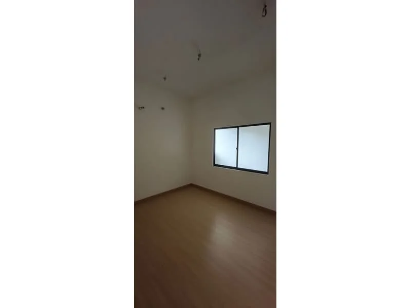 Room features: light wood flooring, white painted walls, single window, ceiling lights.