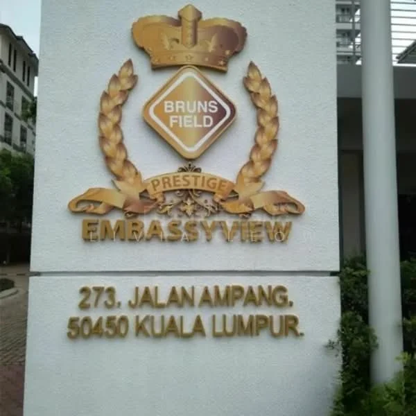 Exterior features: white painted facade, decorative emblem with laurel wreath, gold and silver color scheme, address plaque, landscaped surroundings, brick paving; style: modern.
