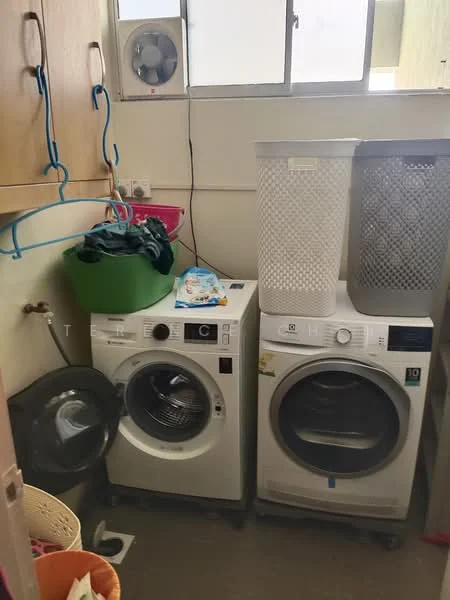 Laundry features: front-load washing machine, tumble dryer, plastic laundry basket, green storage bin, clothes hanging rack, window for natural light, tile flooring, wall-mounted ventilation fan.