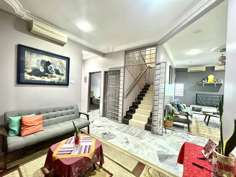 Living features: grey fabric sofa, colorful throw pillows, round coffee table with maroon tablecloth, marble flooring, wall-mounted air conditioning unit, framed artwork on wall, decorative plants, area rug with geometric pattern; style: modern. Hallway features: staircase with white steps, metal railing, light-colored walls, decorative wall paneling; style: modern.