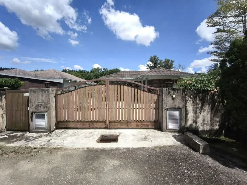 Exterior type: detached bungalow; features: wooden gate, concrete driveway, stone wall, landscaped garden, mature trees, single-storey, roof with overhang, two air conditioning units visible; style: modern.