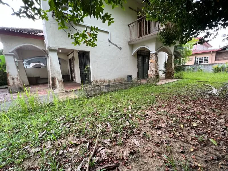 Exterior type: detached bungalow; features: two-storey building, white painted facade, balcony on upper floor, arched doorways, exposed stone feature, manicured lawn, overgrown grass, surrounding greenery, paved pathway, parking area, gated entrance; style: traditional.