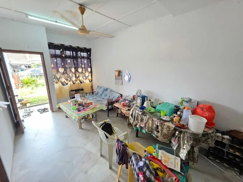 Living features: white painted walls, marble flooring, ceiling fan, sofa, coffee table, multiple plastic chairs, decorative curtains, various kitchen appliances, dining table with tablecloth, open doorway, visible outdoor area, cluttered decor; view: garden.