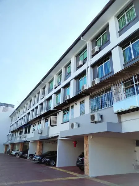 Exterior type: linked terrace house; features: white painted facade, grey accent panels, multiple wall-mounted split AC units, ground-level parking area, stone cladding at base, balconies with metal railings, large windows with green frames, car parking spaces visible; style: modern.