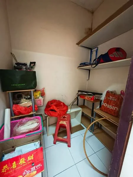 Room features: white tiled flooring, light beige painted walls, shelves mounted on the wall, plastic storage boxes, red plastic stool, various bags and items stored, cardboard boxes, wooden shelving unit.