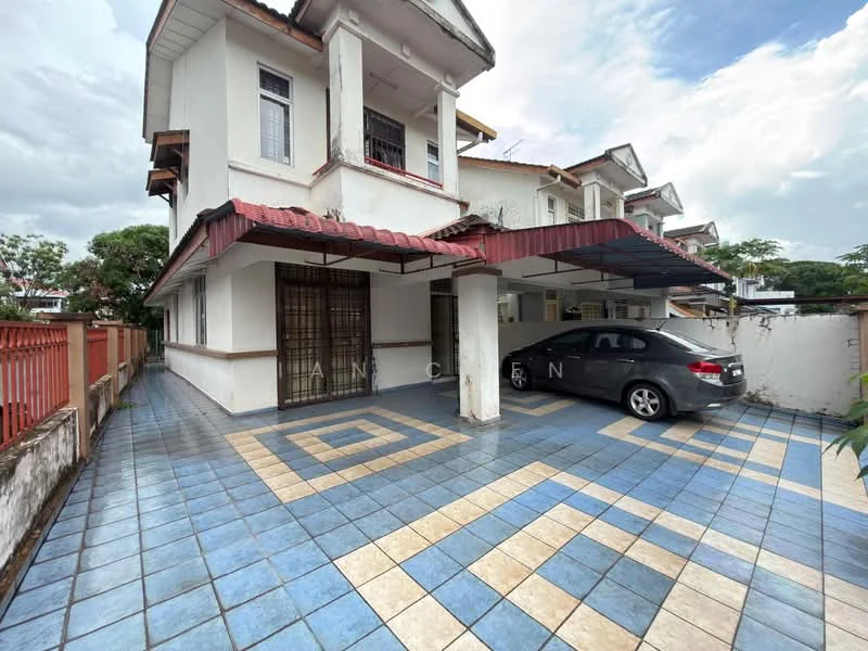 Exterior type: semi-detached house; features: paved driveway with geometric pattern, car porch with awning, white painted facade, red tiled roof, two-storey structure, surrounded by greenery, fenced perimeter, visible parking space for one car; style: modern.